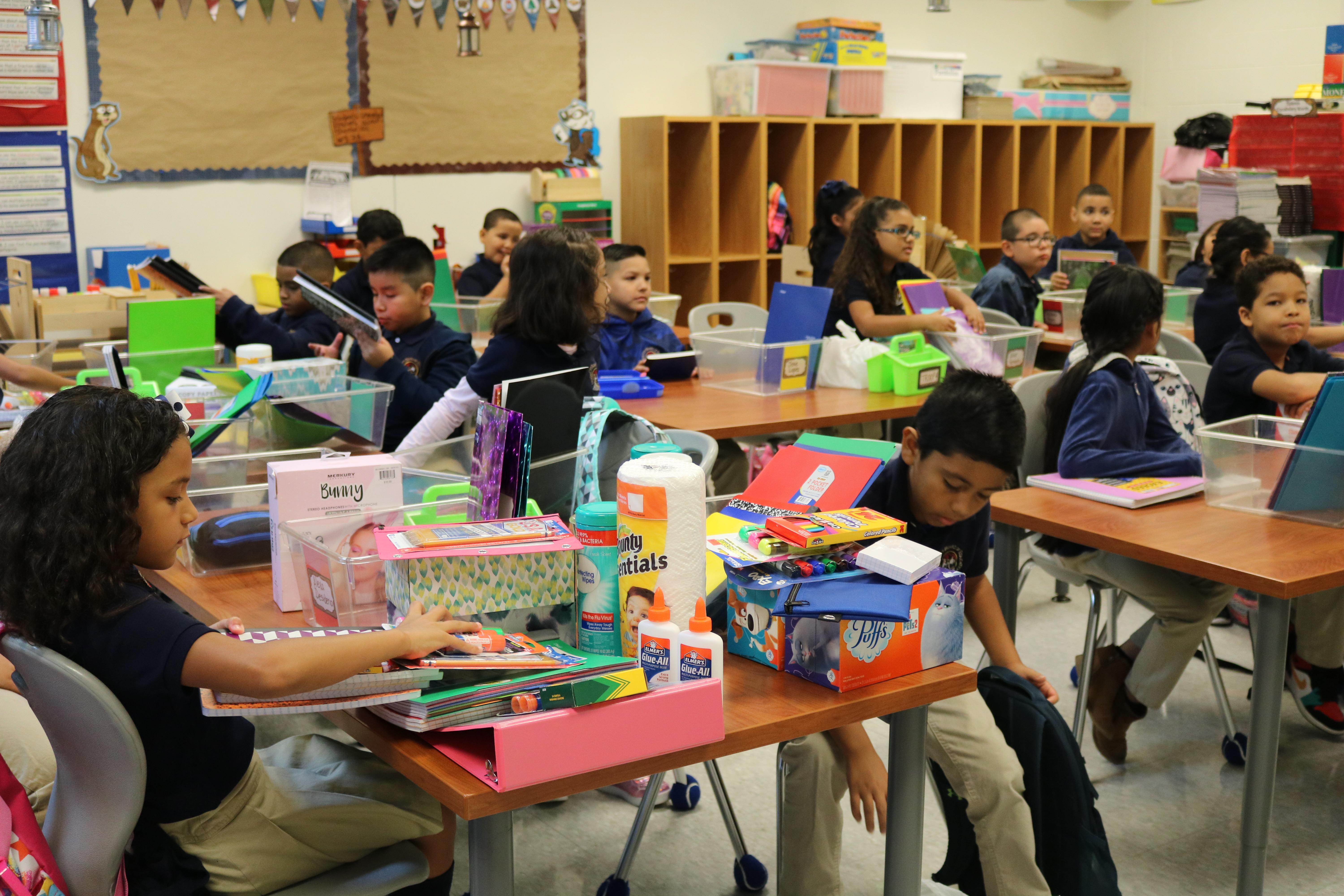 students sitting in class with their supplies