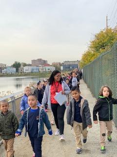 children walking side by side with their teacher on walking path of the viaduct