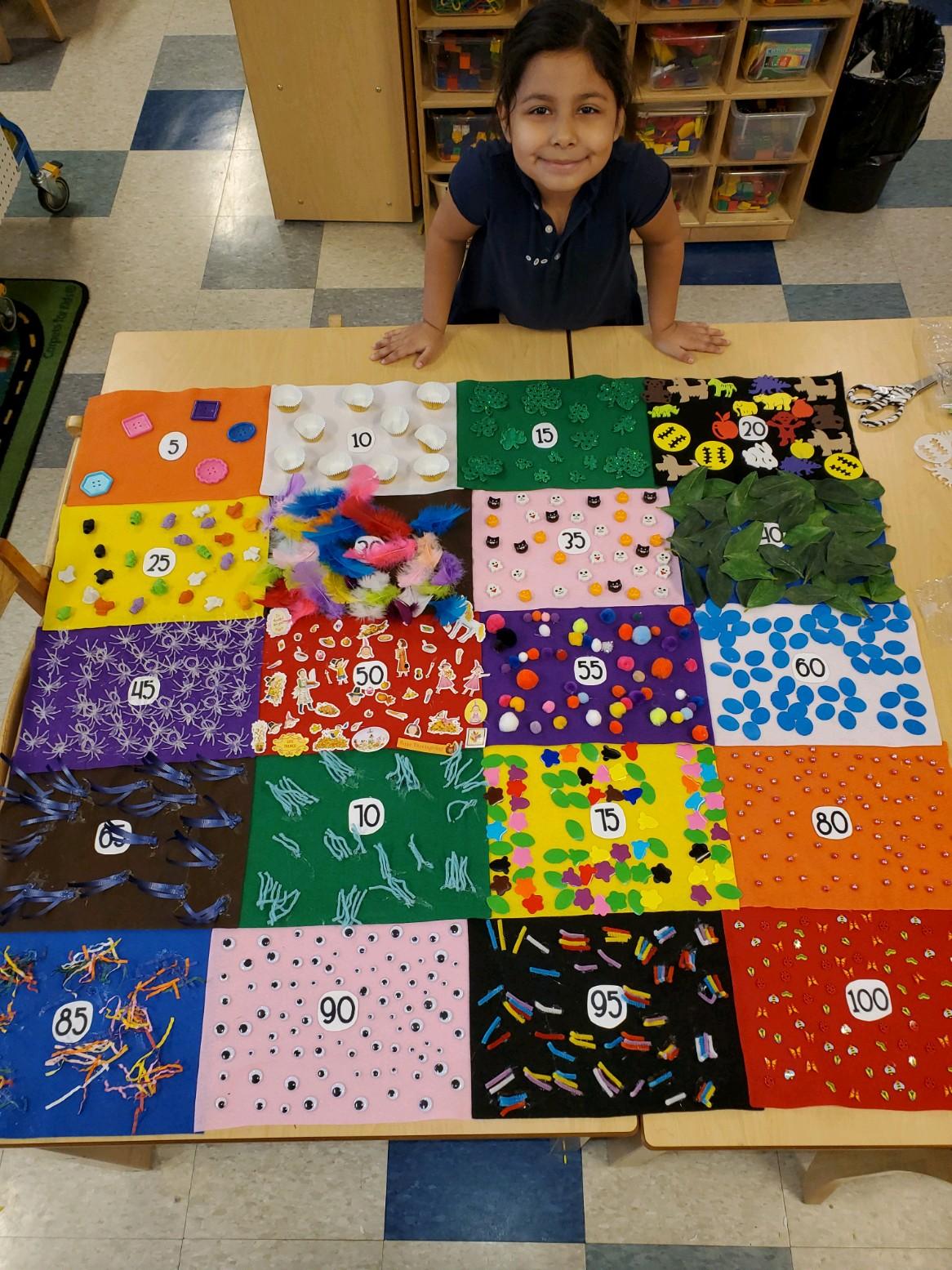 Girl in front of 100 Day quilt