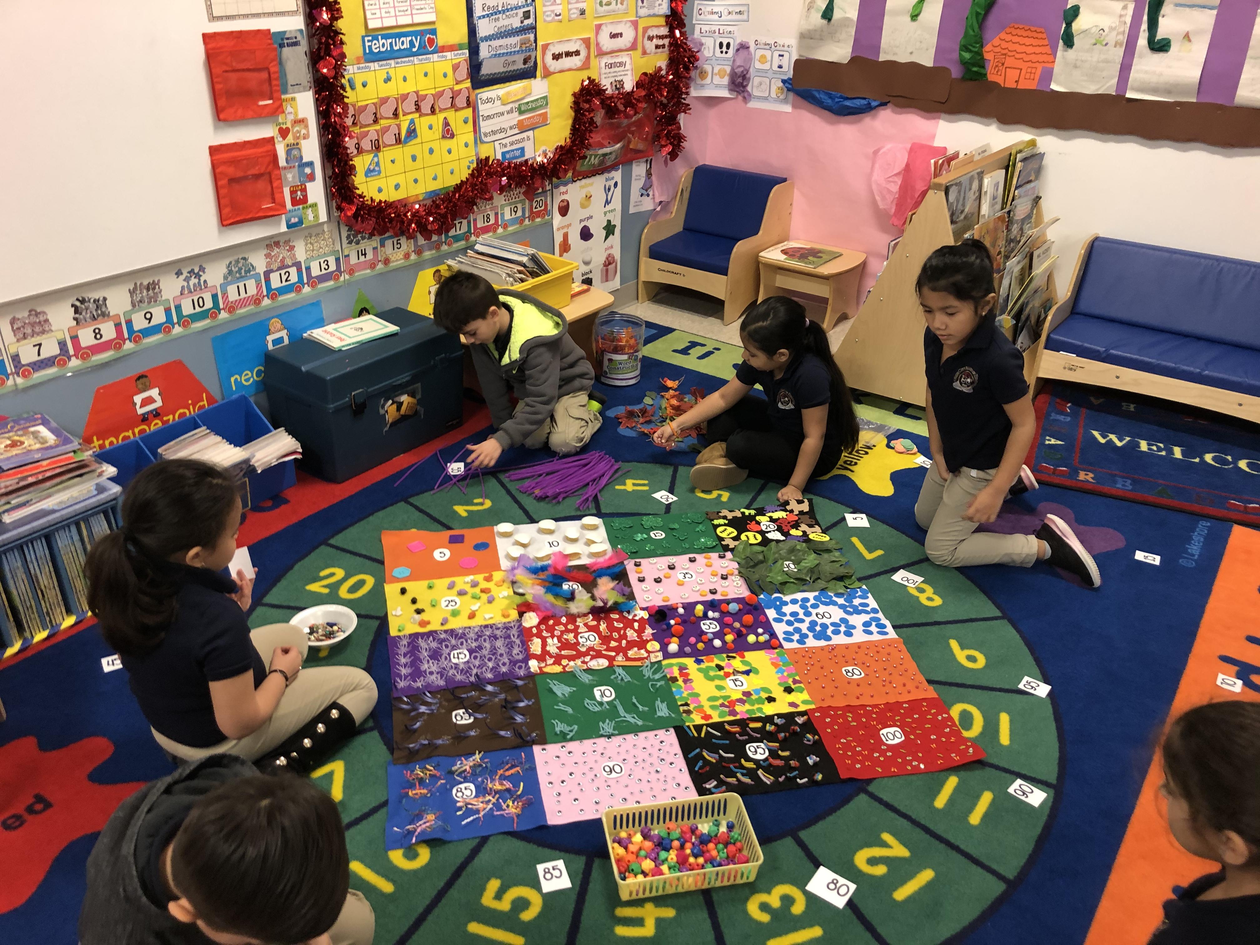 several children sitting on the class rug gathering items