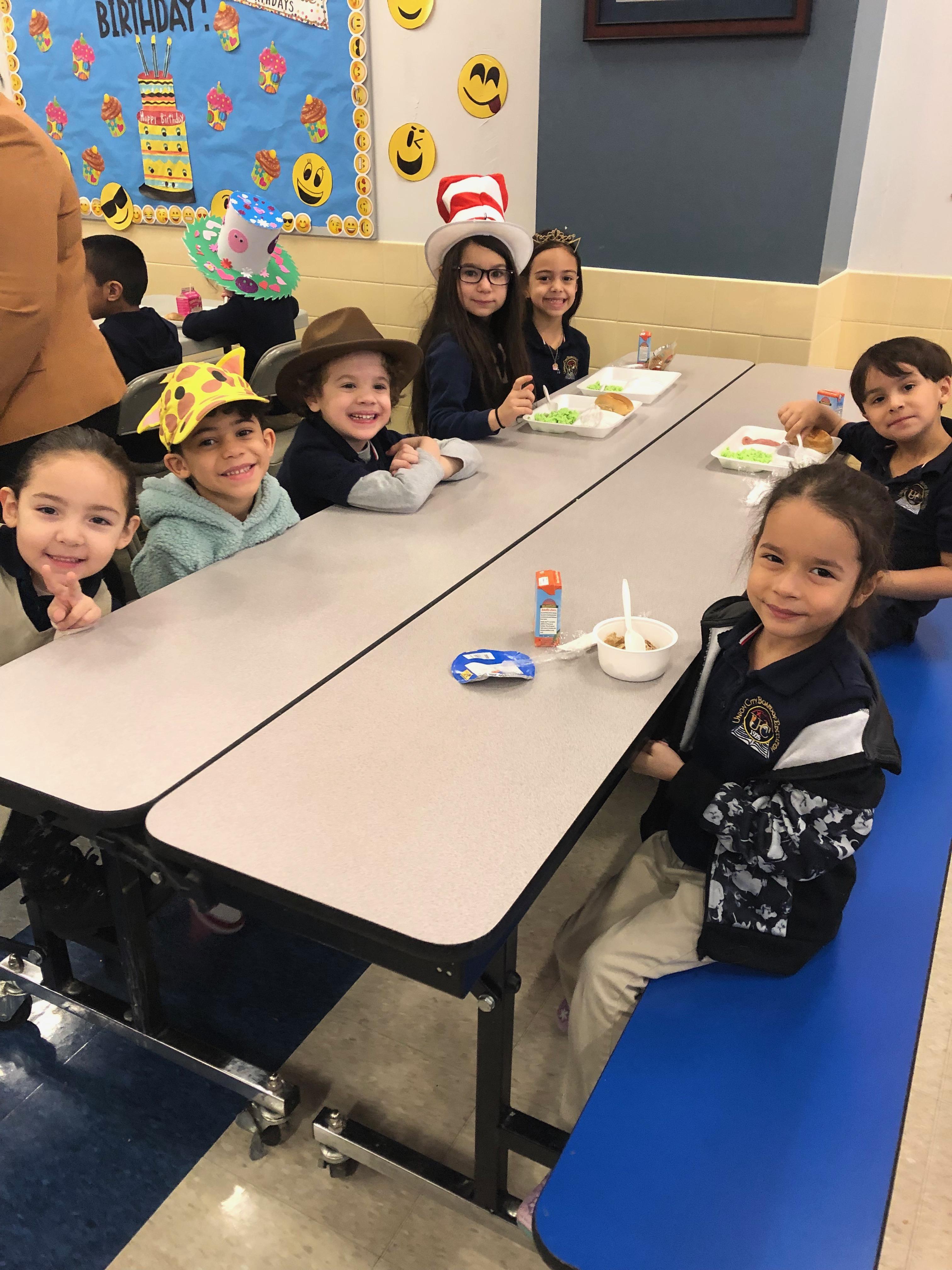 group of children enjoying breakfast wearing wacky hats